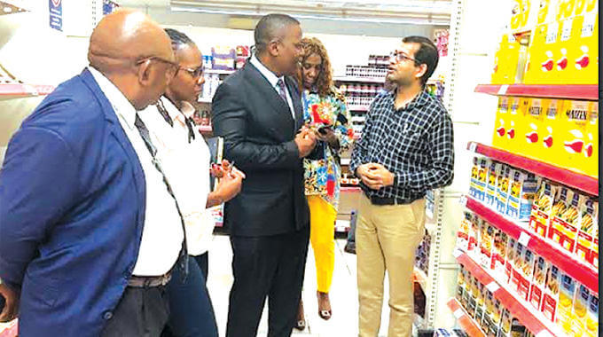 El director ejecutivo de ZimTrade, Allan Majuru (centro), interactúa con un distribuidor de productos frescos en Malabo, Guinea Ecuatorial, durante un estudio de mercado realizado para determinar el potencial de los productos de Zimbabue en el mercado.